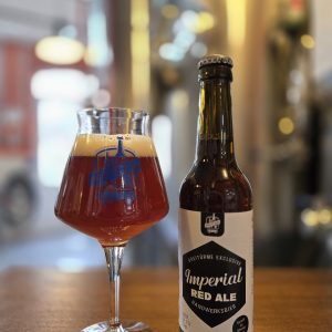 Das Imperial Red Ale im Whiskyfass gereift, hier zu sehen im Glas und in der Flasche.