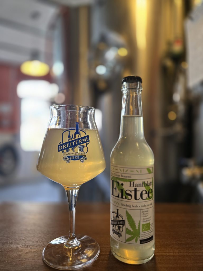 Das Bild zeigt den hanfblatt Eistee der Dreitürme Brauerei im Glas und in der Flasche.