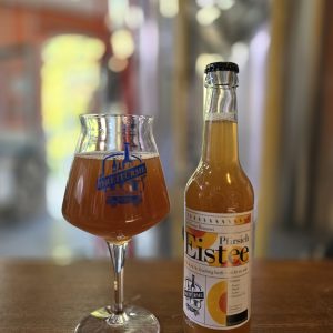 Pfirsich Eistee abgebildet in der Flasche und im Glas in der Drei Türme Brauerei