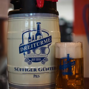 5 Liter Frischefass mit einen gefüllten Bierglas, was das Pils der Dreitürme Brauerei beinhaltet.