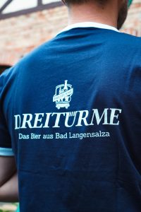 Dreitürme Fan-Shirt Rückseite am Kleiderbügel vor einem Biertank